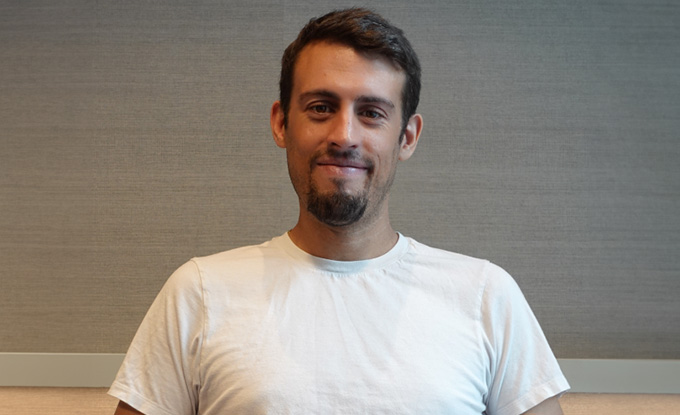 man smiling casually in a plain white shirt with short hair and a beard promoting positivity and connection in a modern environment 9 inspirational moments