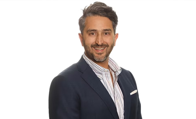 smiling man in dark suit with light shirt and stylish hair showing confidence and professionalism in a portrait suitable for seven business contexts