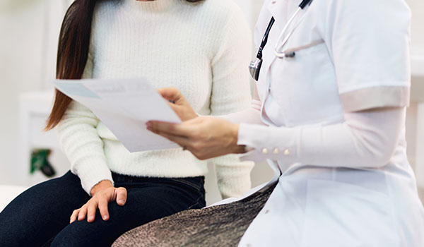 medical consultation between a doctor and a patient discussing important health information while seated in a clinic setting focused on wellness and health care tips related to 5 easy steps to improve health