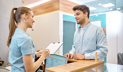 two people interacting at a modern reception desk discussing information with a clipboard professional atmosphere friendly service three options